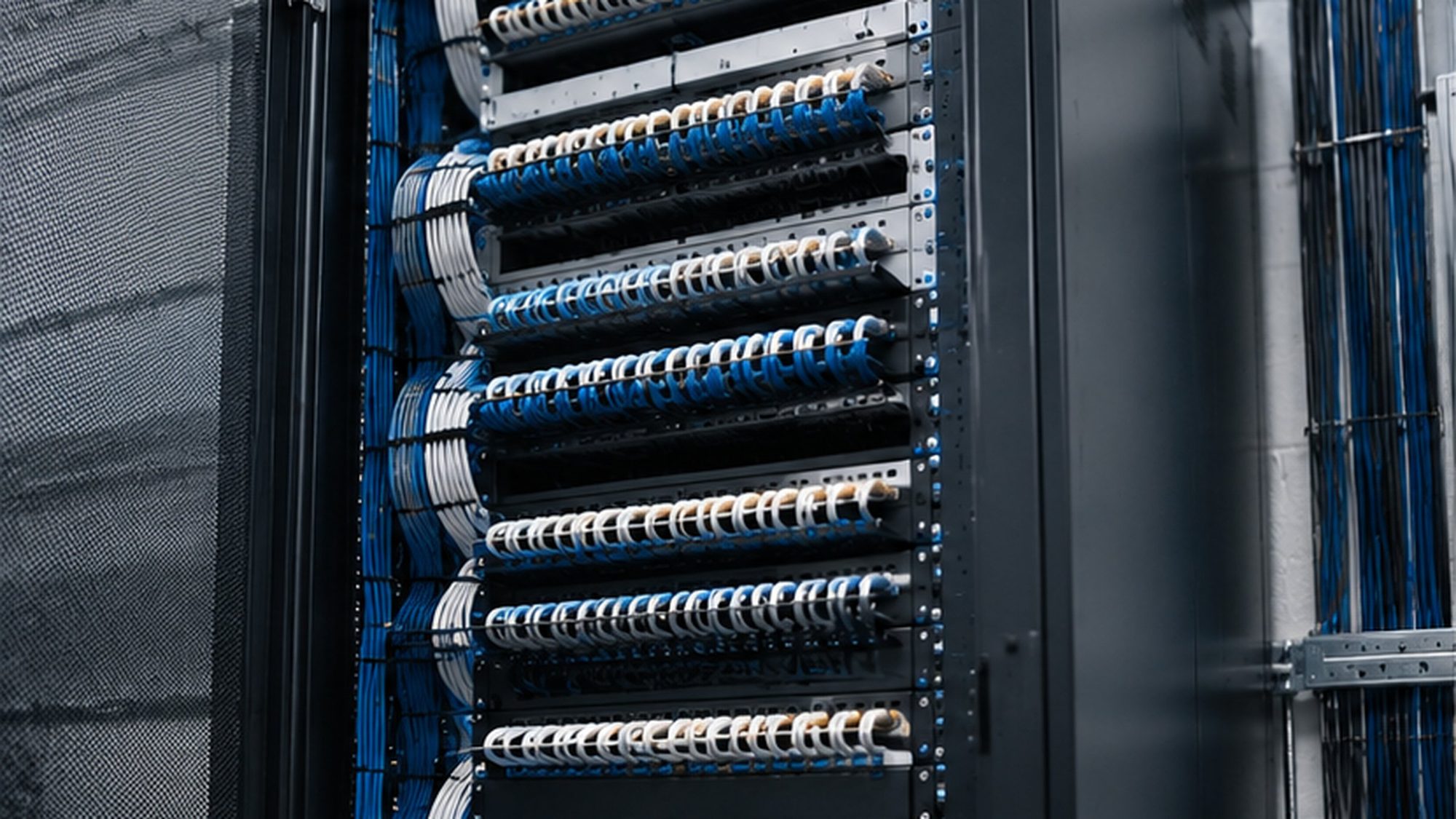 A full rack cabinet with immaculate patch panels in a school comms room.