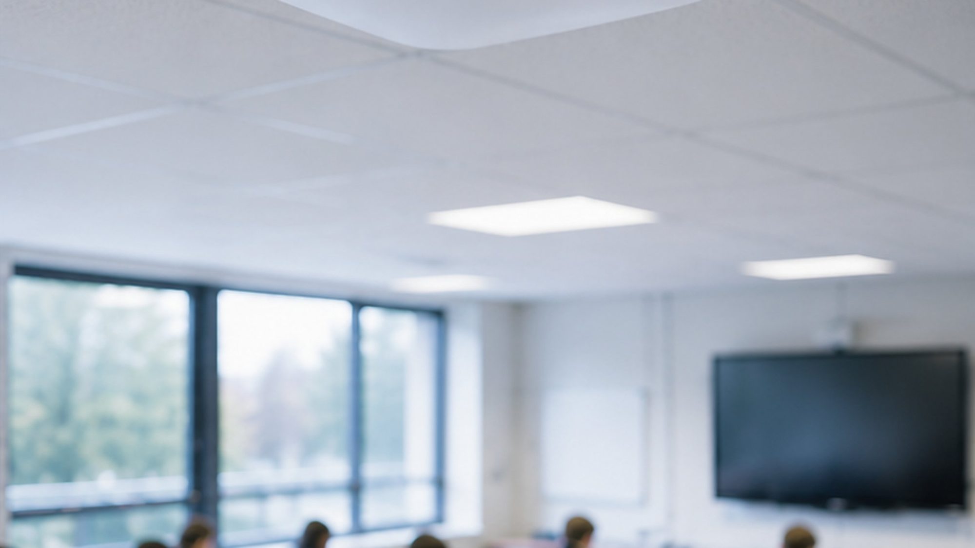 A ceiling wireless access point above a daylit classroom.